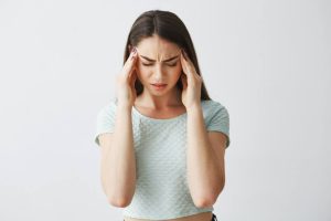 אישה מחזיקה את הראש עם 2 הידיים